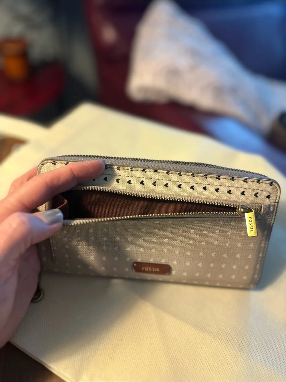Fossil Putty and white exterior with black hearts; with brown lining Wristlet